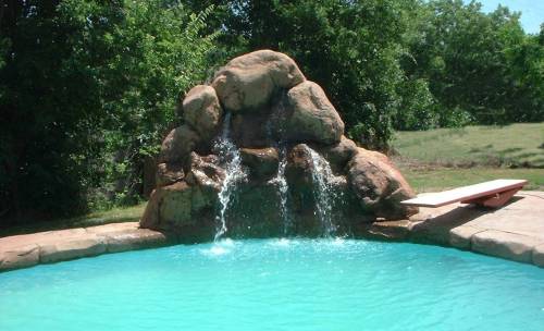 Grande Falls precast waterfall enhances existing pool in Hallettsville, Texas.